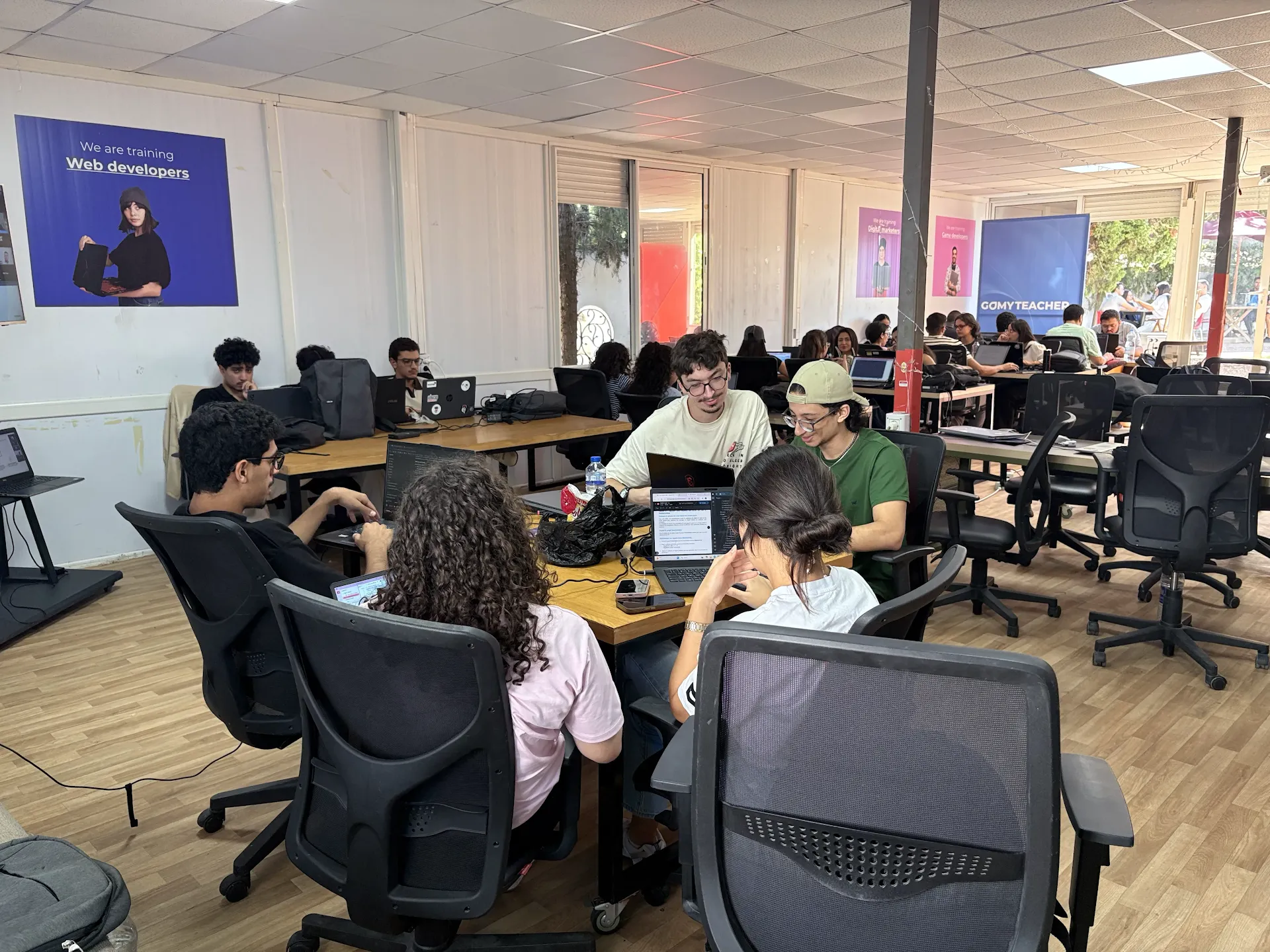Participants collaborating with laptops during Come Build with AI.