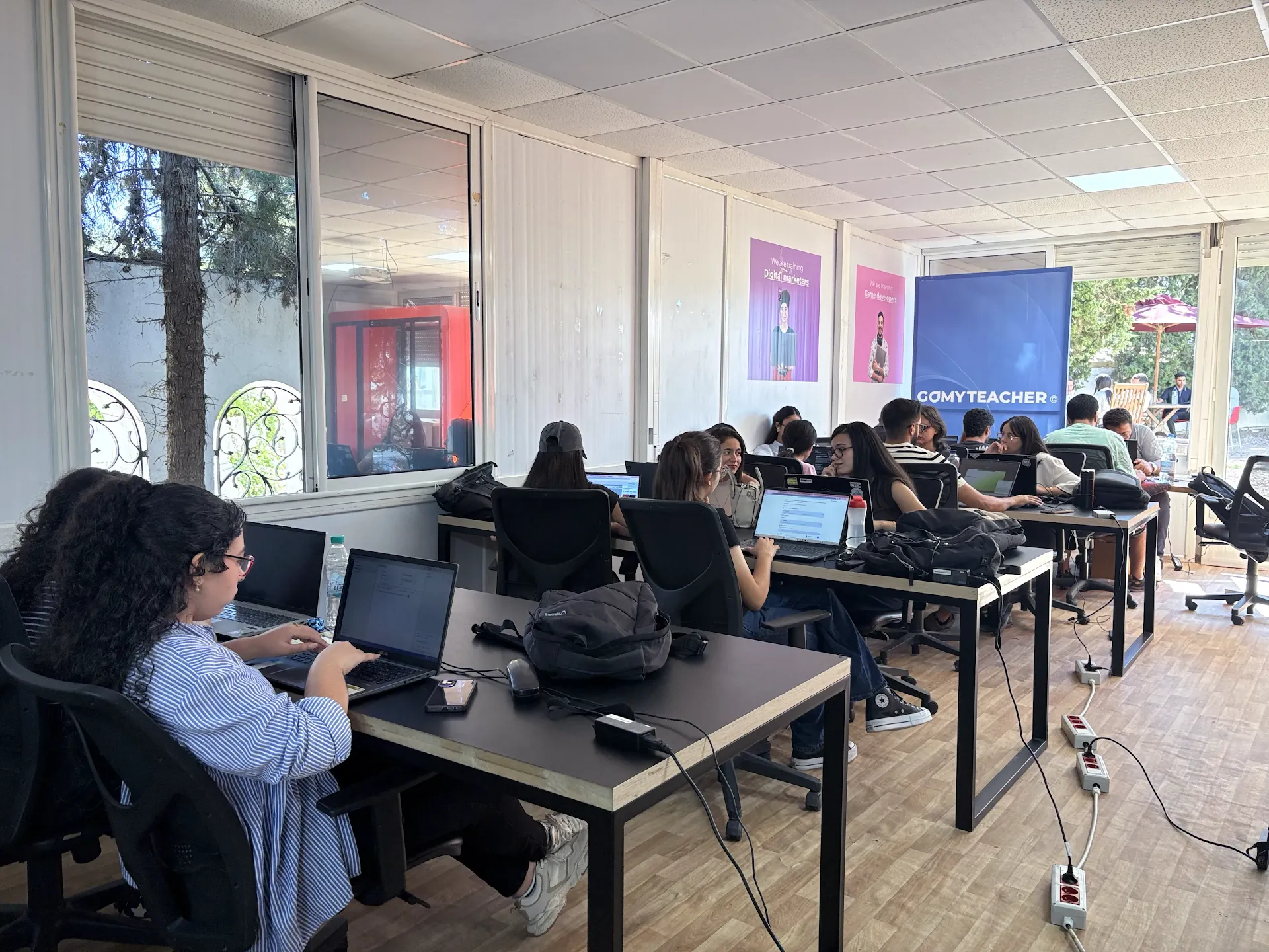 Participants collaborating with laptops during Come Build with AI.