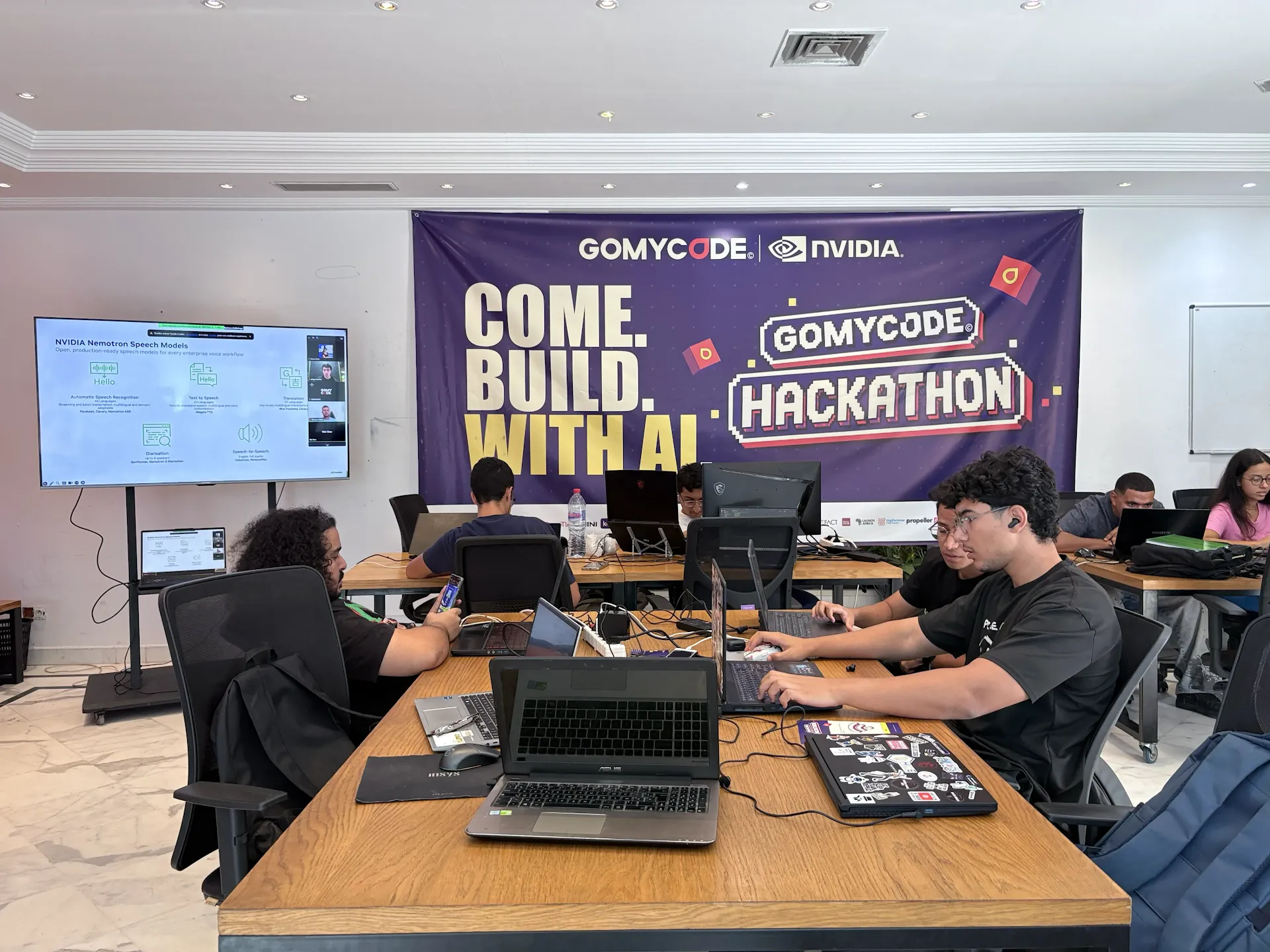 Participants collaborating with laptops during Come Build with AI.