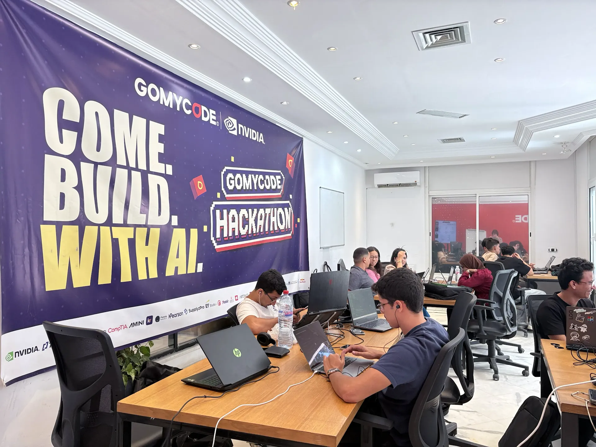 Participants collaborating with laptops during Come Build with AI.